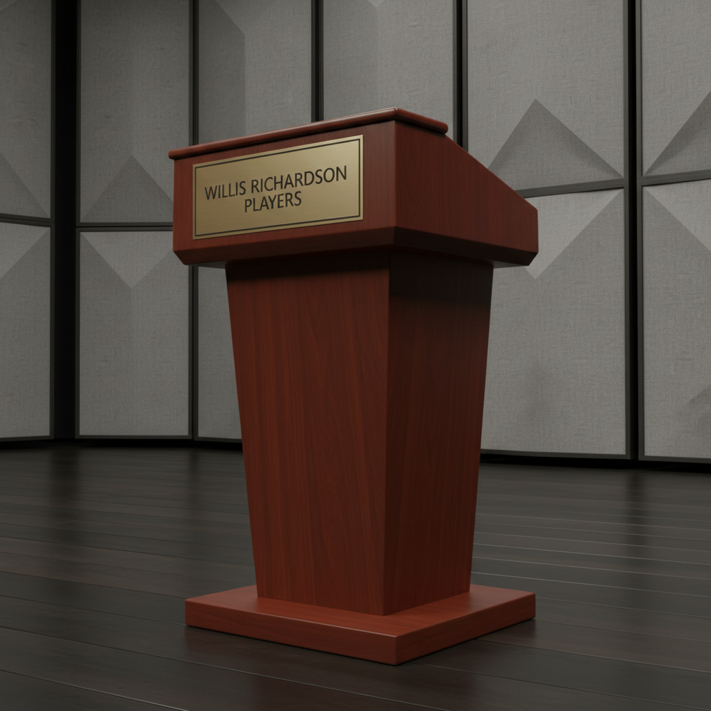 An immaculate wooden theater podium, finished in smooth mahogany with muted brass plaque engraved with 'Willis Richardson Players,' set on a stage of dark, matte floorboards. Behind, tall, neutral-gray acoustic panels line the space, providing a modern, unobtrusive backdrop. Diffused, even studio lighting casts minimal shadow, illuminating clean lines of the podium and emphasizing clarity and formality. The camera captures the setting from a three-quarter view, slightly elevated, giving balanced depth and professional focus. The tone is confident and dignified, reflecting a corporate, non-profit environment dedicated to community education in Black theatre.